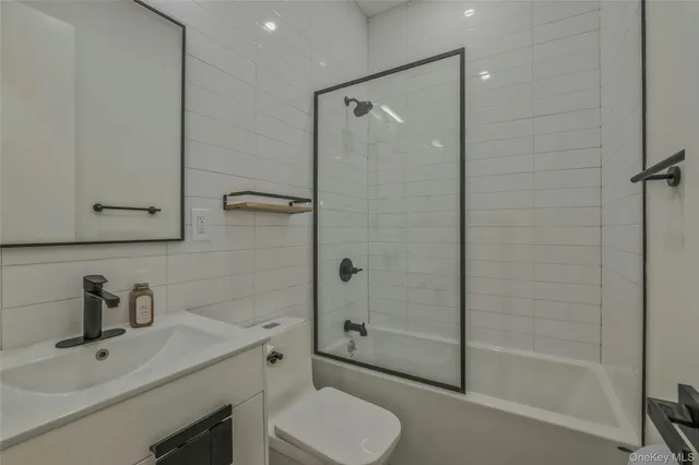 a bathroom with a shower sink vanity mirror and toilet