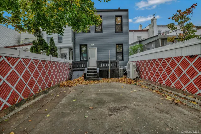 a backyard of a house with wooden fence and a bench