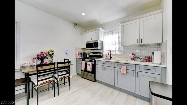 a kitchen with cabinets stainless steel appliances and dining table