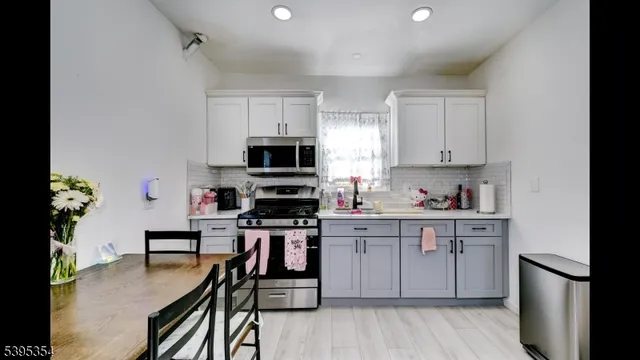 a kitchen with stainless steel appliances a stove a sink cabinets and a refrigerator