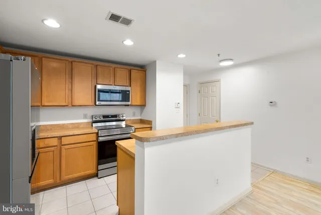 a kitchen with refrigerator cabinets and wooden floor