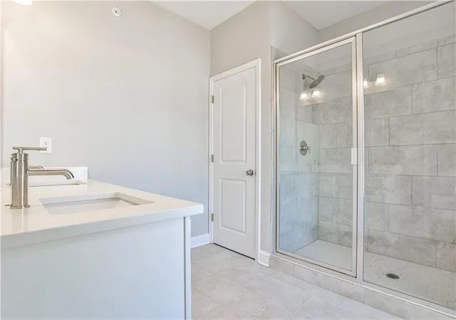 a bathroom with a shower sink and mirror