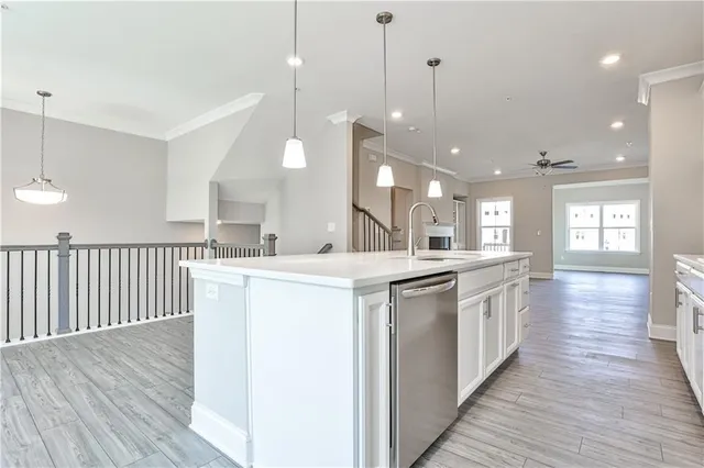 a large kitchen with kitchen island a sink wooden floor and a large window