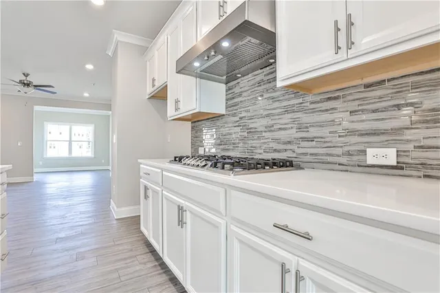 a kitchen with cabinets wooden floor and a stainless steel appliances