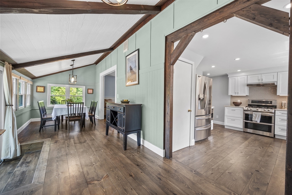 63 River Street Andover, MA 01810 - Photo 21 of 40 a kitchen with stainless steel appliances granite countertop a stove top oven a refrigerator a dining table and chairs with wooden floor