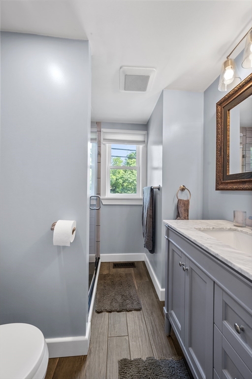 63 River Street Andover, MA 01810 - Photo 30 of 40 a bathroom with a granite countertop sink toilet and window