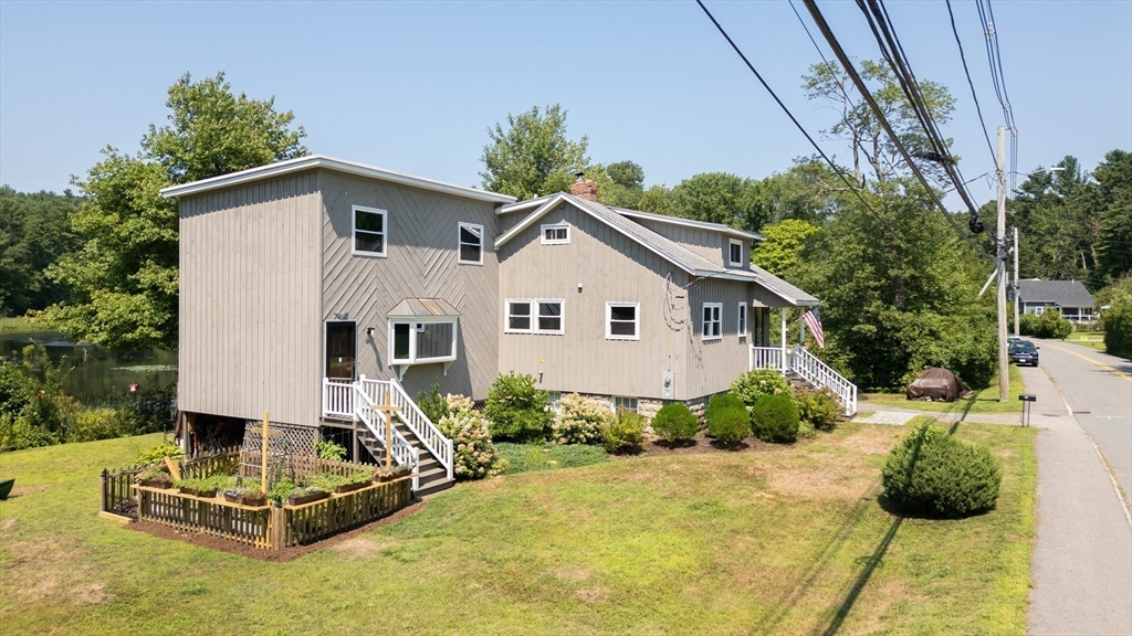 63 River Street Andover, MA 01810 - Photo 9 of 40 a view of a white house with a yard and plants