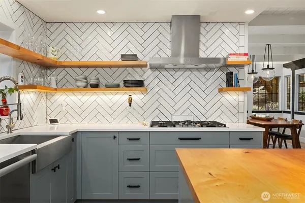 a kitchen with stainless steel appliances granite countertop a sink and a stove