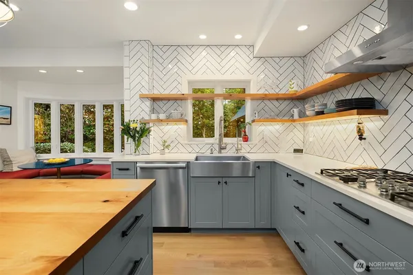 a kitchen with stainless steel appliances granite countertop a sink a stove and a wooden cabinets