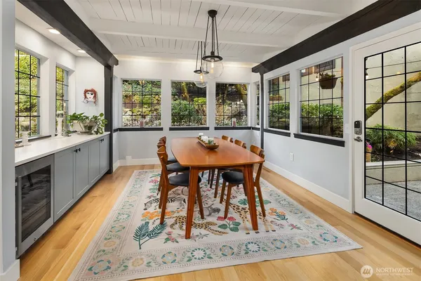 a dining room with wooden floor and large windows