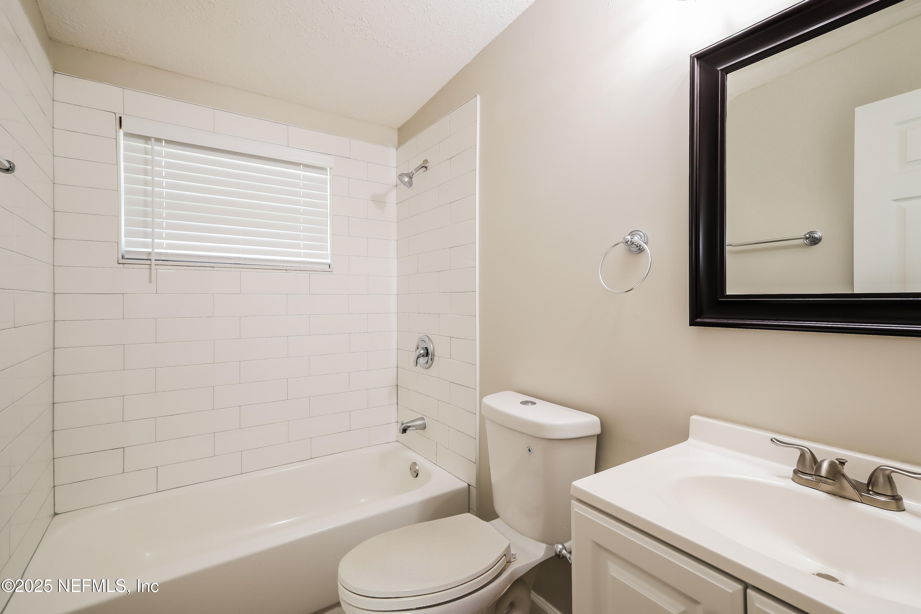 9246 Spottswood Road Jacksonville, FL 32208 - Photo 13 of 15 a bathroom with a toilet a sink a mirror and bathtub