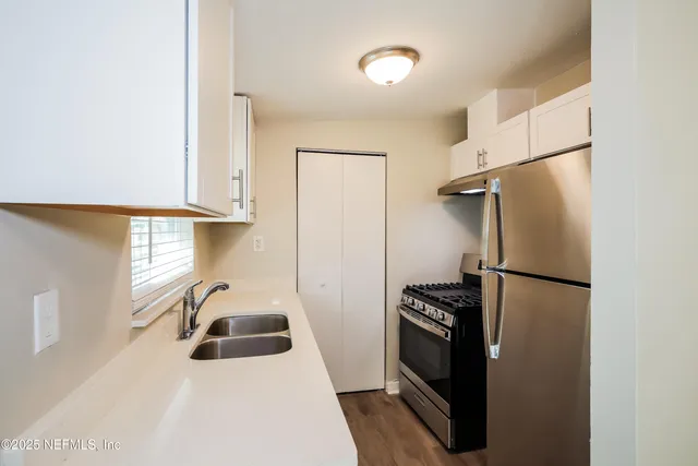 a white refrigerator freezer and a stove sitting inside of a kitchen