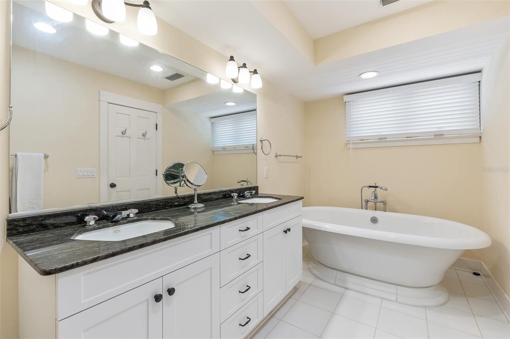 160 1st Street East Boca Grande, FL 33921 - Photo 15 of 43 a bathroom with a double vanity sink a mirror and a bathtub