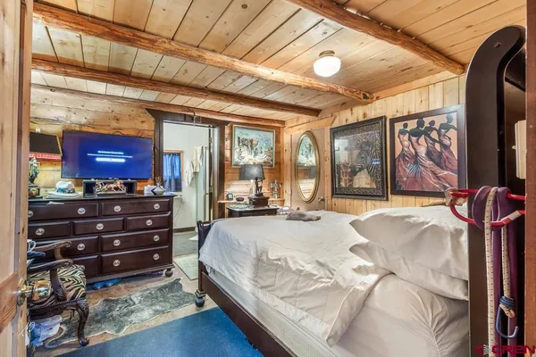 a bedroom with a bed a mirror and paintings on the wall