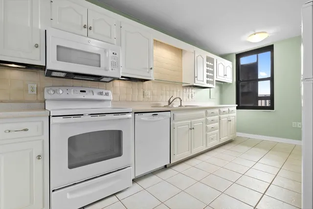 a kitchen with granite countertop a sink appliances cabinets and counter space