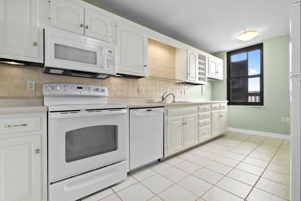 40 Village Road, Unit 1601 Middleton, MA 01949 - Photo 16 of 38 a kitchen with granite countertop white cabinets stainless steel appliances and sink