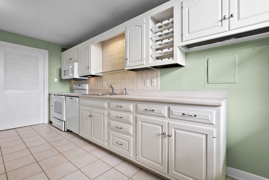 40 Village Road, Unit 1601 Middleton, MA 01949 - Photo 17 of 38 a kitchen with white cabinets and white appliances