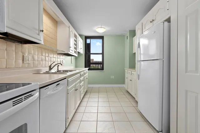 a view of a kitchen with white cabinets
