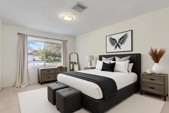 a spacious bedroom with a bed and glass window