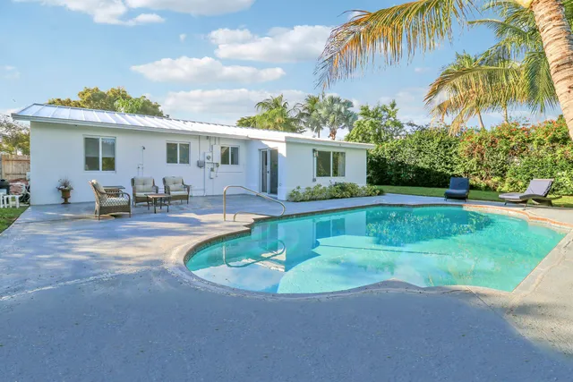 a view of a house with a swimming pool and a yard