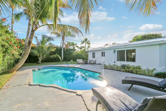 a view of a house with swimming pool and sitting area