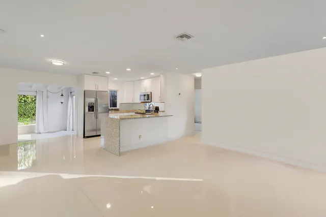 a view of kitchen with white cabinets and wooden floor