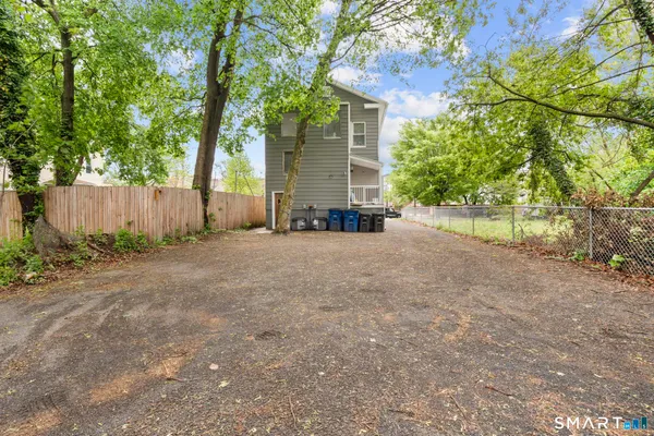 a view of a house with a backyard and a tree