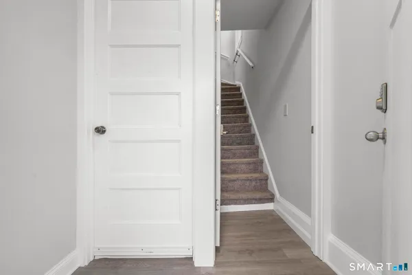 a view of a hallway with wooden floor and entryway