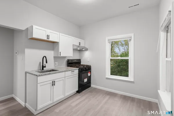 a kitchen with a sink cabinets and a window