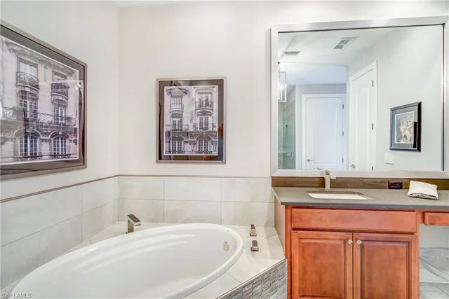 a bathroom with a bathtub sink and mirror