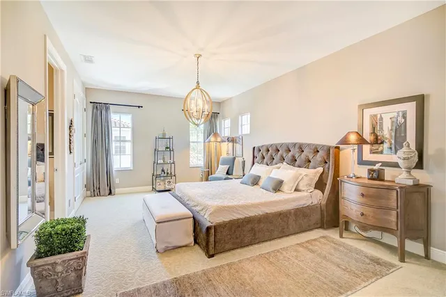 a bedroom with a large bed and chandelier