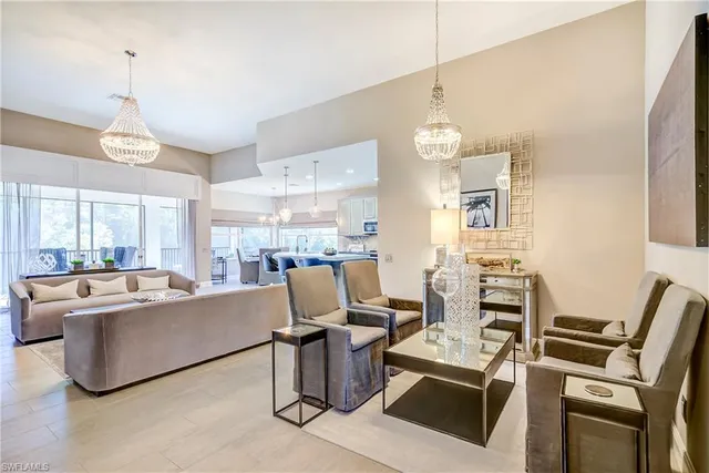 a living room with couches a dining table chairs and a kitchen view