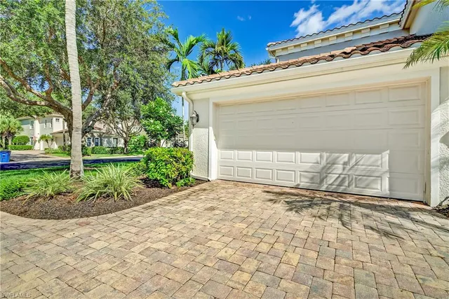 a view of a house with a yard and potted plants
