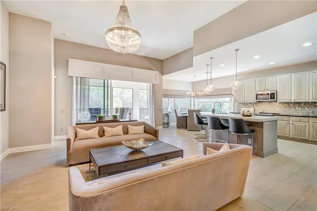 a living room with stainless steel appliances kitchen island granite countertop a couch and a view of kitchen