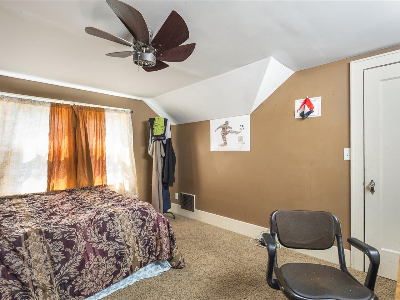 1247 West Logan Street Freeport, IL 61032 - Photo 22 of 34 a bedroom with a bed and a chair with a large window
