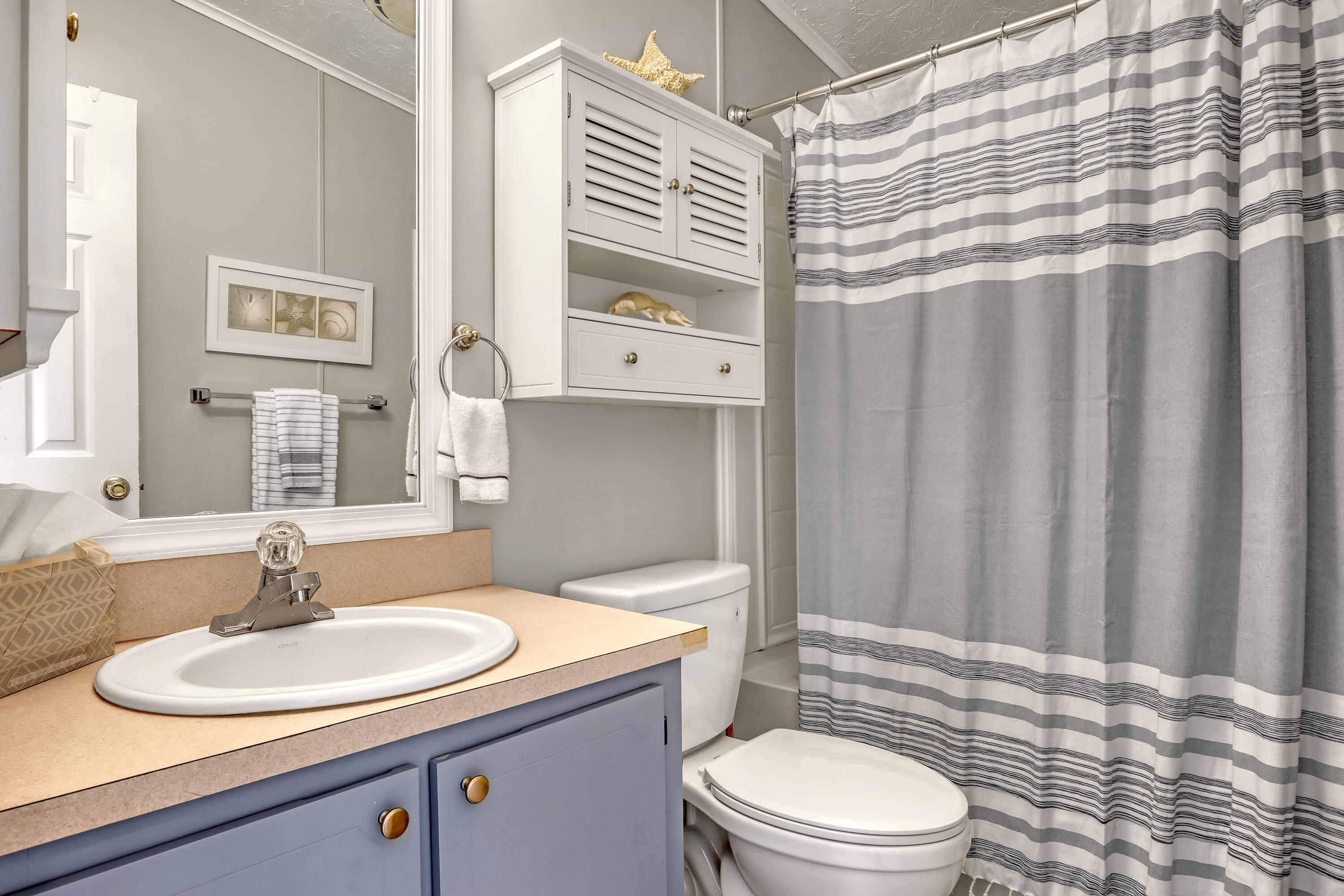 464 Dolphin Circle Barefoot Bay, FL 32976 - Photo 23 of 42 a bathroom with a sink a toilet and shower curtain