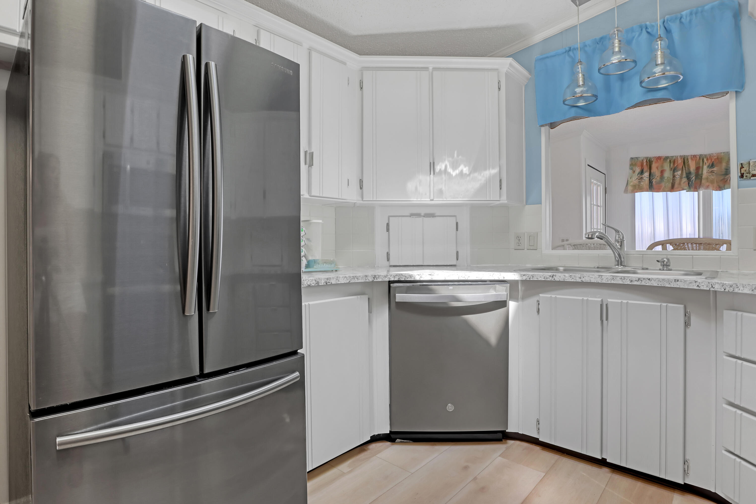 464 Dolphin Circle Barefoot Bay, FL 32976 - Photo 9 of 42 a kitchen with granite countertop white cabinets and refrigerator