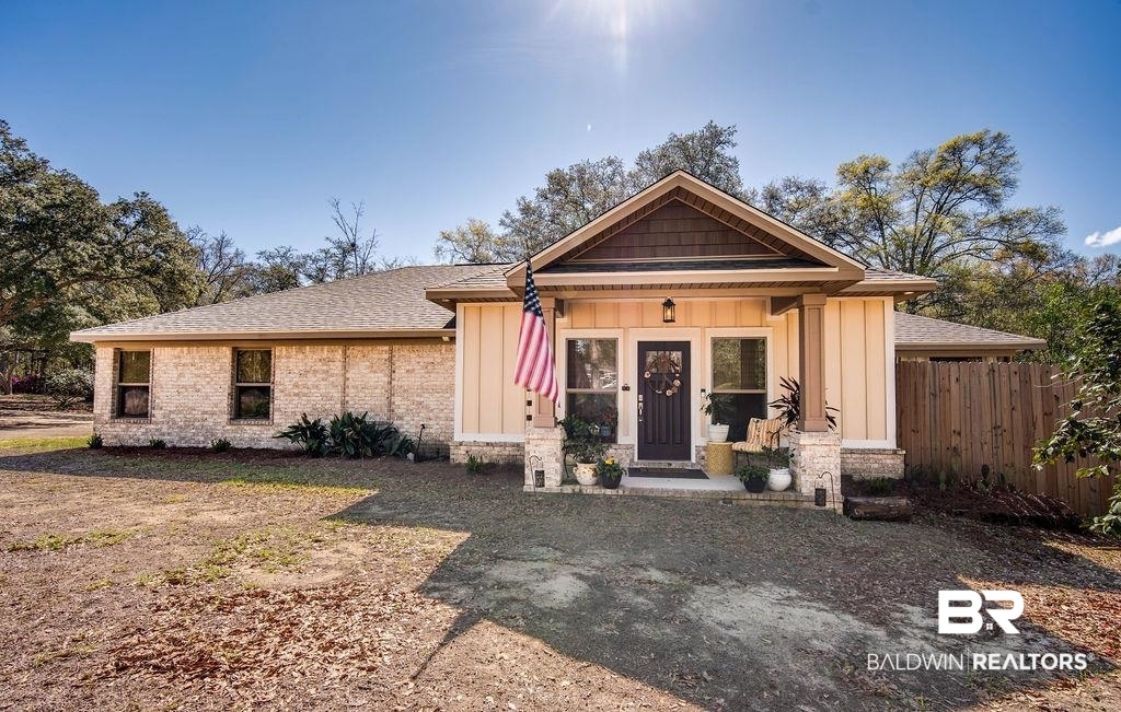 7420 Pake Road Saraland, AL 36571 - Photo 1 of 35 View of front of house featuring brick siding, fence, and board and batten siding