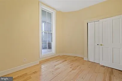 a view of empty room with wooden floor and entryway