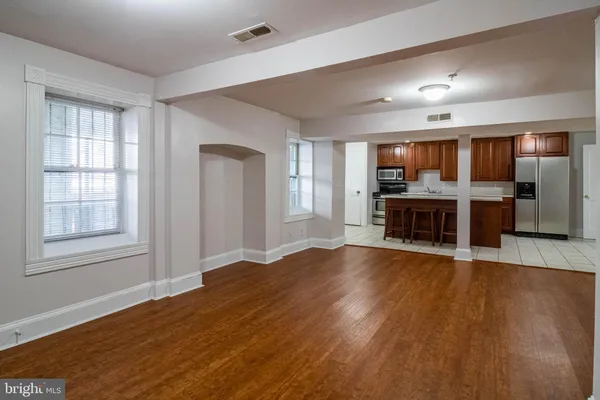 a view of empty room with wooden floor and fireplace