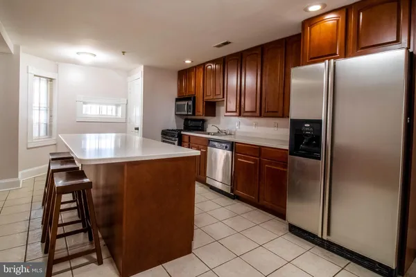 a kitchen with stainless steel appliances granite countertop a refrigerator a sink a stove and island