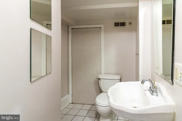 a bathroom with a toilet a sink and mirror