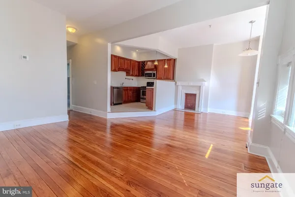 a view of a room with kitchen and wooden floor