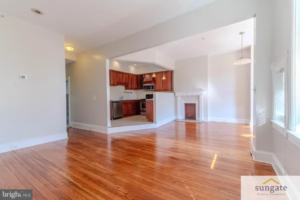 a view of empty room with wooden floor