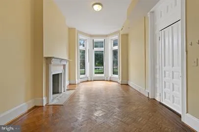 a view of an empty room with a fireplace and a window