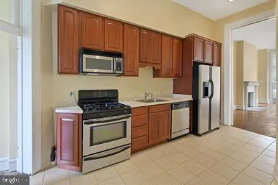 a kitchen with granite countertop wooden cabinets and stainless steel appliances