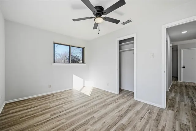 a view of a room with wooden floor and a ceiling fan