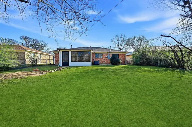 a view of a house with a big yard and large trees