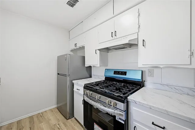 a stove top oven sitting inside of a kitchen