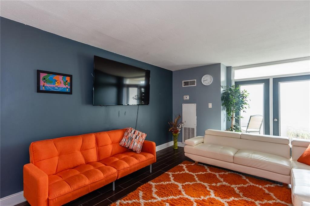 375 Ralph McGill Boulevard Northeast, Unit 1701 Atlanta, GA 30312 - Photo 14 of 33 a living room with a couch and a flat screen tv